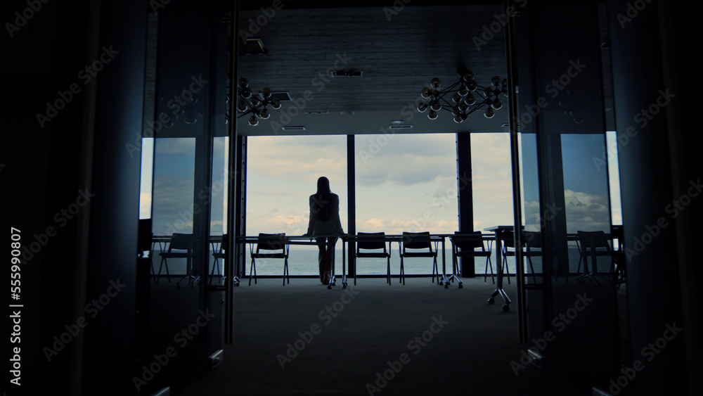 Woman silhouette enjoying break in conference room. Calm beautiful sea view.
