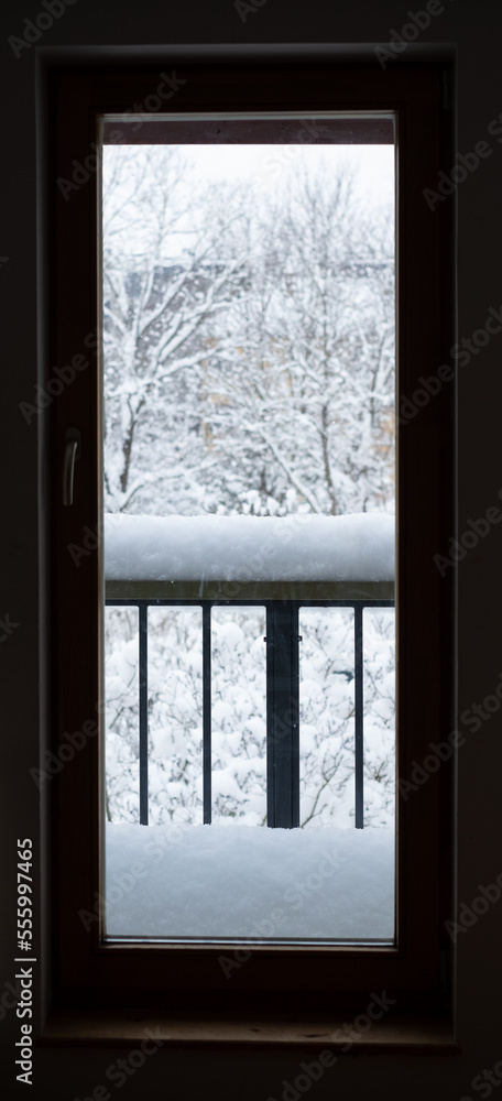 Fototapeta premium Looking through window from indoor to outdoor. Major snowfall. Everything covered under snow. Winter weather.