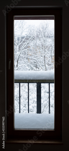 Looking through window from indoor to outdoor. Major snowfall. Everything covered under snow. Winter weather.