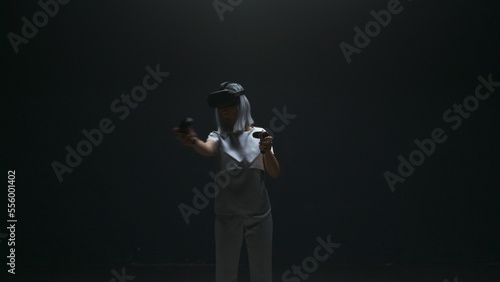 Beautiful girl wearing vr headset in blinking light. Futuristic gamer playing