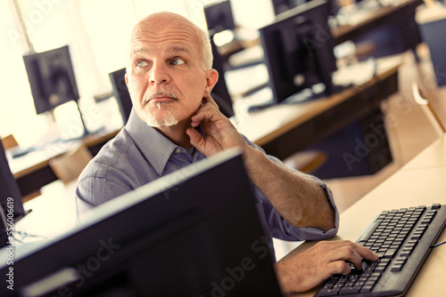 Man at computer listens to colleague's opinion photo