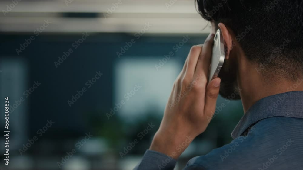 Back rear view unknown male businessman young man entrepreneur HR manager boss talk mobile phone in office calling distant client use cell communication speak telephone wireless business conversation