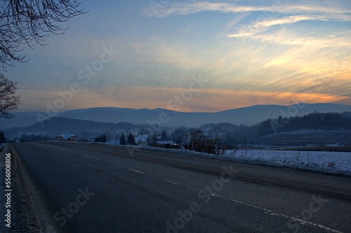 sunset in the mountains and snowy road