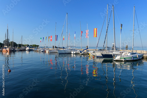 Row of boats and colorful European flags in the harbor marina on Lake Garda (Lago di Garda) at Bardolino in Veneto, Italy photo