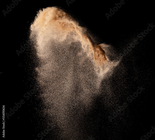 Small size fine Sand flying explosion, Golden grain wave explode. Abstract cloud fly. Yellow colored sand splash silica in Air. Element Black background Isolated high speed throwing freeze shot
