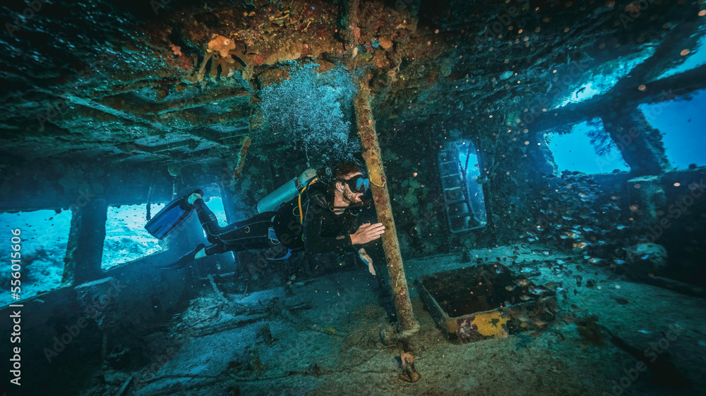 scuba diver exploring inside a military shipwreck