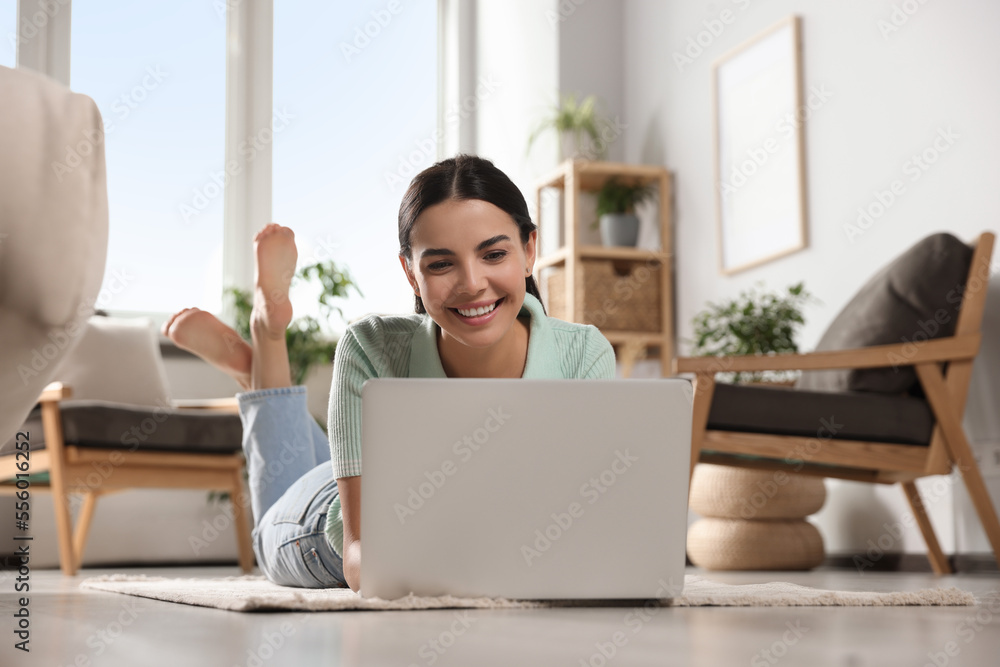 Young woman working with laptop on floor at home Young woman working with laptop on floor at home