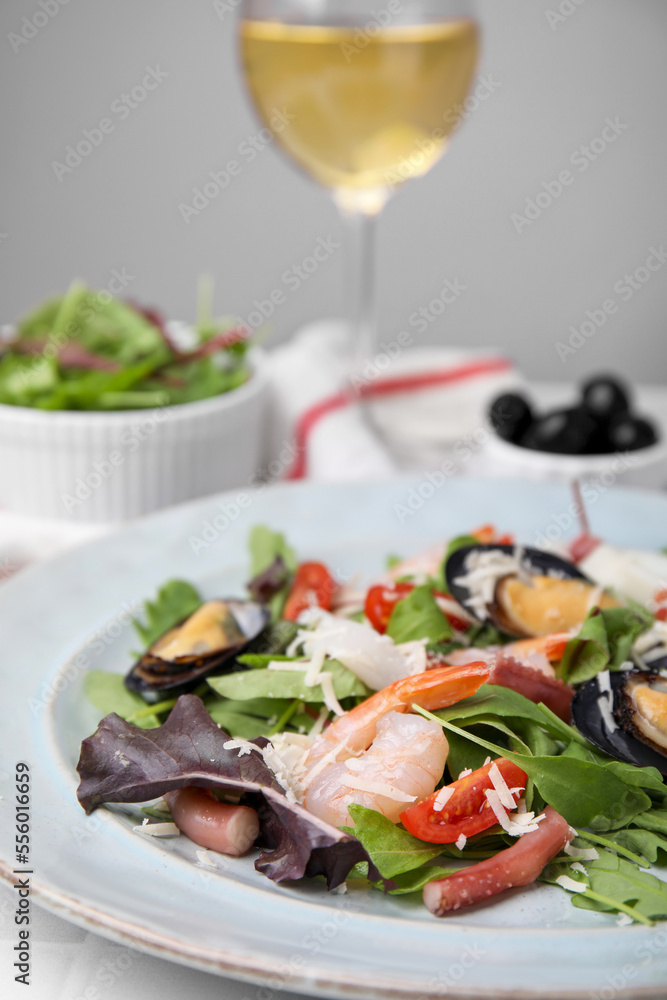 Plate of delicious salad with seafood on white tiled table, closeup Plate of delicious salad with seafood on white tiled table, closeup