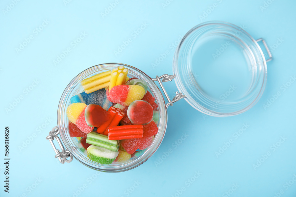 Tasty colorful jelly candies in glass jar on light blue background, top view Tasty colorful jelly candies in glass jar on light blue background, top view
