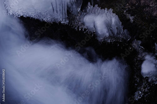 A landscape photograph of snow in a mountain stream in the middle of winter. Mysterious feeling.
