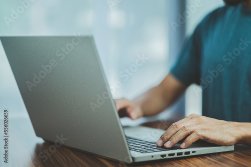 People using computer Side view of male hands typing on laptop keyboard