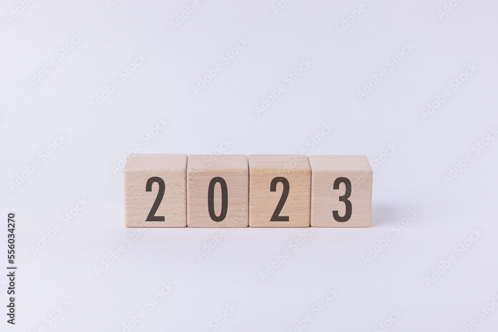 Flipping wood cube block from 2022 to 2023 text isolated in white background. New year goal, action plan, business plan, finance and marketing strategy concept. Flipping wood cube block from 2022 to 2023 text isolated in white background. New year goal, action plan, business plan, finance and marketing strategy concept.