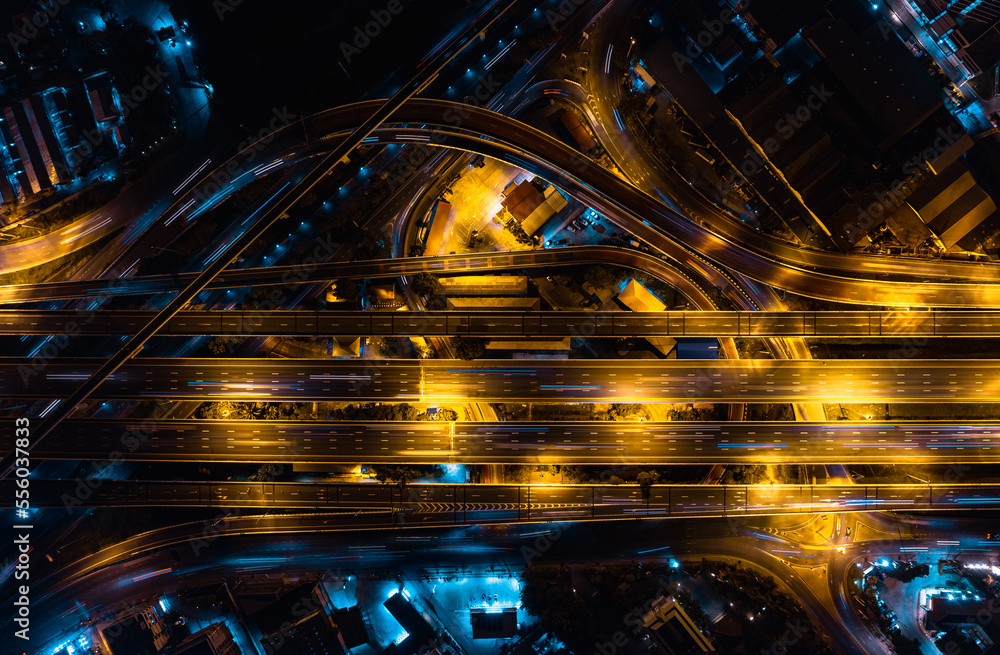Aerial top view of Modern Multilevel Motorway Junction with Expressway, Road traffic an important infrastructure in Thailand. Bangkok urban Mass Transit Project (Pink Line Monorail). Night scene. Aerial top view of Modern Multilevel Motorway Junction with Expressway, Road traffic an important infrastructure in Thailand. Bangkok urban Mass Transit Project (Pink Line Monorail). Night scene.