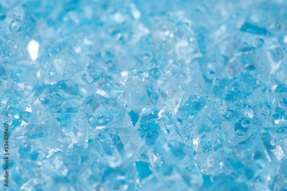 Ice cubes and ice shards with water drops on a blue background. The concept of cold and freshness Ice cubes and ice shards with water drops on a blue background. The concept of cold and freshness