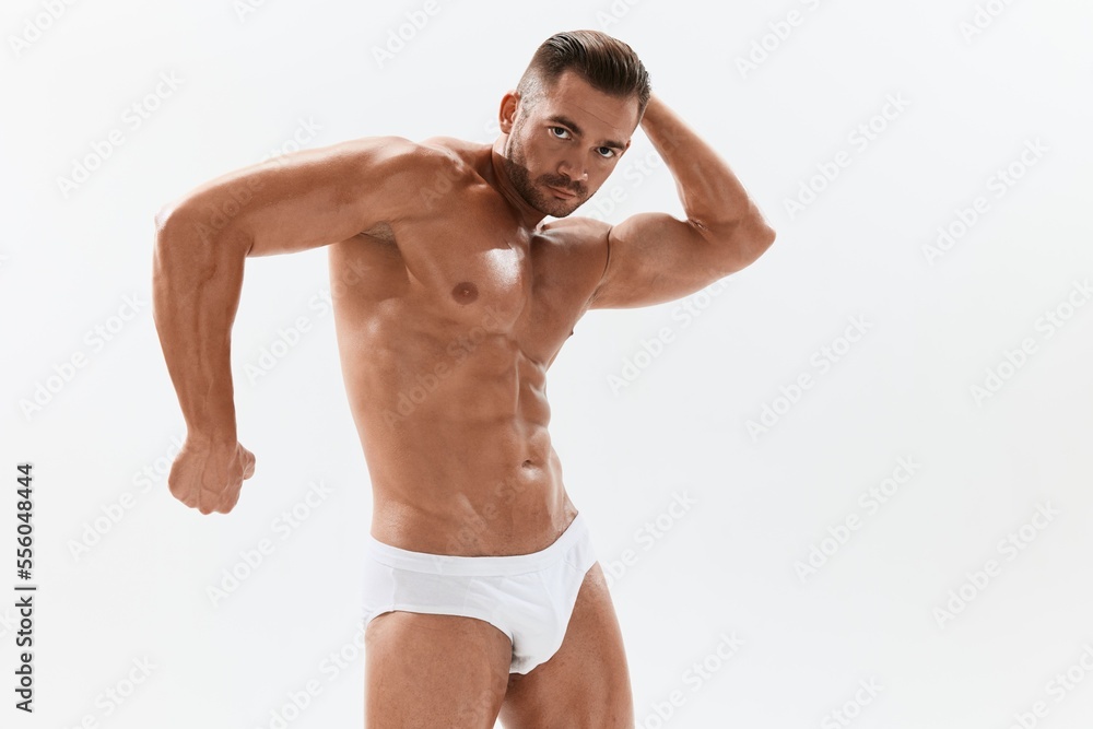 Man athletic body bodybuilder in briefs with naked torso abs full-length in the background, fitness classes. Advertising, sports, active lifestyle, competition, challenge concept. Man athletic body bodybuilder in briefs with naked torso abs full-length in the background, fitness classes. Advertising, sports, active lifestyle, competition, challenge concept.