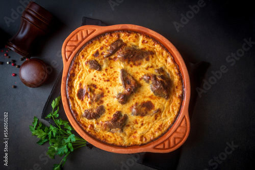 Tave kosi is a national Albanian dish of baked lamb and rice with yoghurt close-up in a pan on the table. horizontal top view from above. Turkish name; Elbasan tava photo