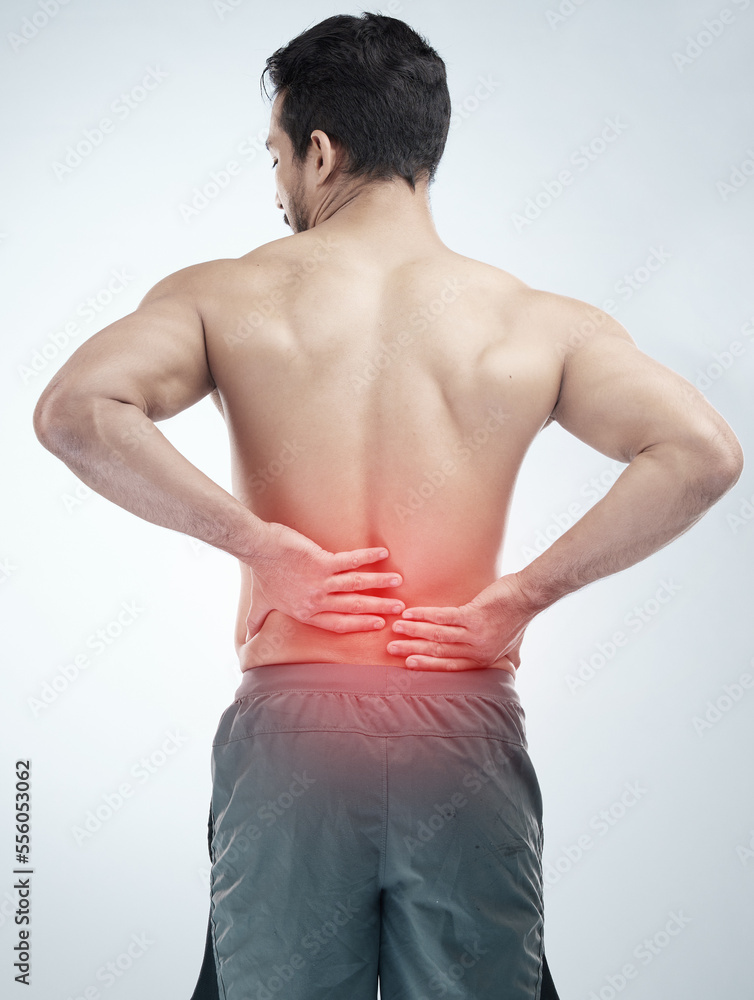 Injury, back pain or man in studio with spine or hurt body problem after training isolated on studio background. Back view, red glow or person with muscle tension, body crisis or emergency accident