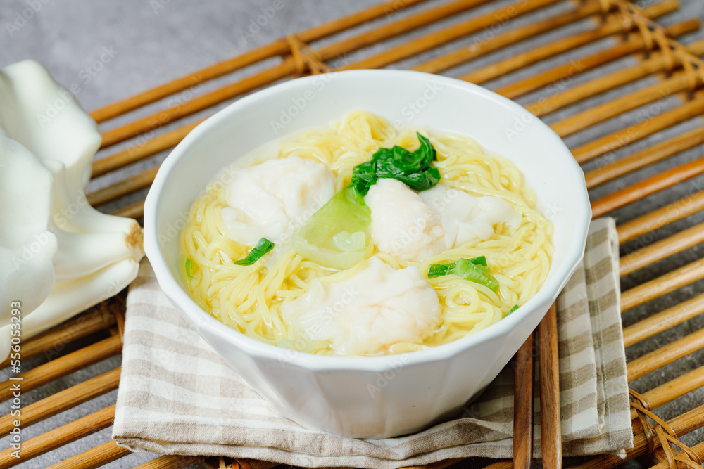 Chinese cuisine shrimp wonton dumpling noodle soup food in white bowl on white table background Chinese cuisine shrimp wonton dumpling noodle soup food in white bowl on white table background