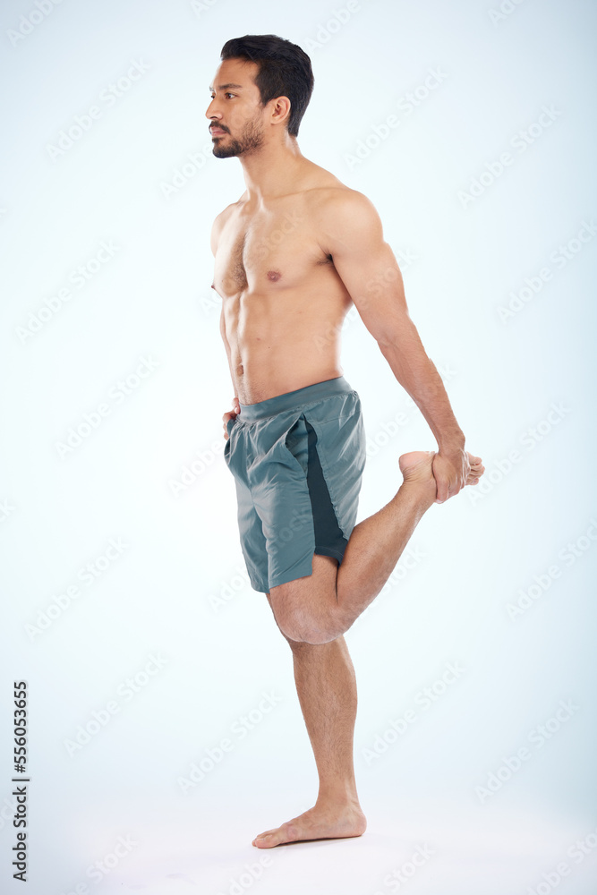 Fitness, health and man stretching leg in studio isolated on a blue background mock up. Sports, body wellness and young male athlete stretch, warm up and preparing for workout, exercise and training.