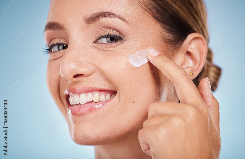 Skincare, beauty and portrait of a woman with face cream for health, wellness and natural face routine. Cosmetic, happy and model with facial lotion, spf or creme isolated by a blue studio background Skincare, beauty and portrait of a woman with face cream for health, wellness and natural face routine. Cosmetic, happy and model with facial lotion, spf or creme isolated by a blue studio background