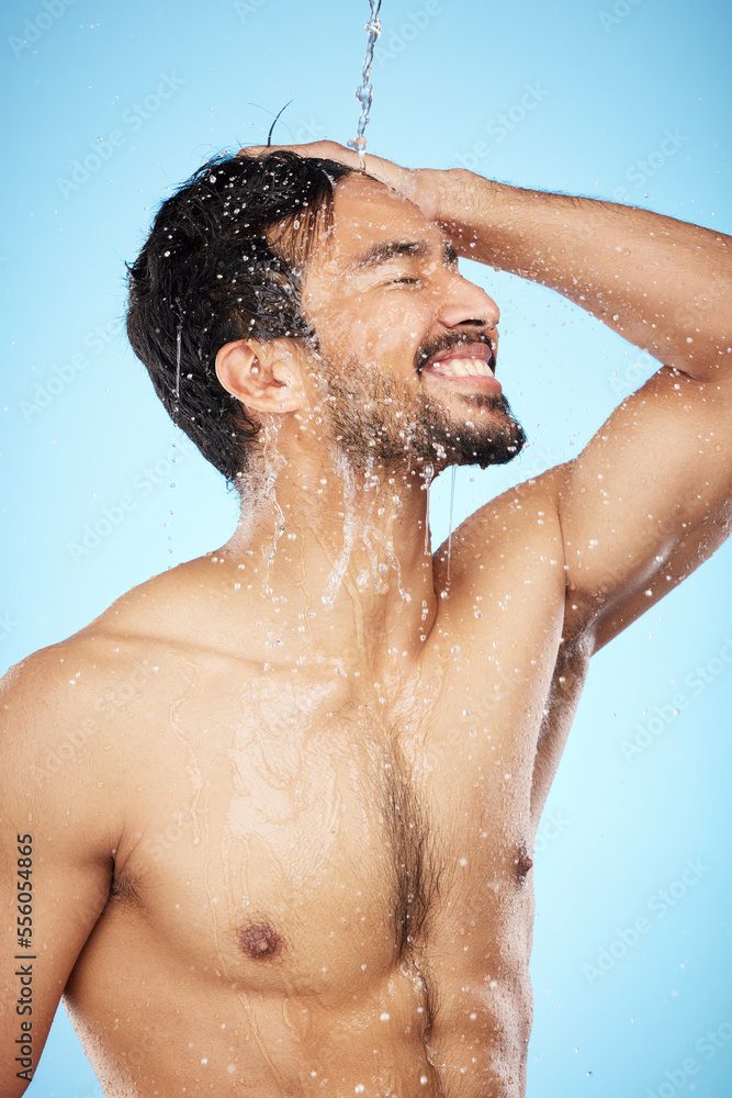 Face, water splash and man in shower cleaning for body care in studio isolated on a blue background. Hygiene, skincare and profile of male model bathing and washing for health, wellness and beauty. Face, water splash and man in shower cleaning for body care in studio isolated on a blue background. Hygiene, skincare and profile of male model bathing and washing for health, wellness and beauty.