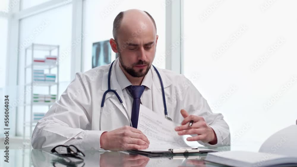 male doctor is consulting a patient in his office . male doctor is consulting a patient in his office .