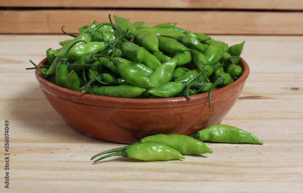 Bowl of Fresh Green Aji Limo Chili Peppers on Wooden Table Bowl of Fresh Green Aji Limo Chili Peppers on Wooden Table