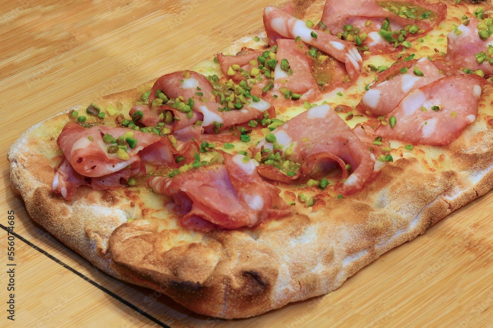 focaccia called PINSA in Italian with Mortadella Sausage and green pistachio grains Stock Photo