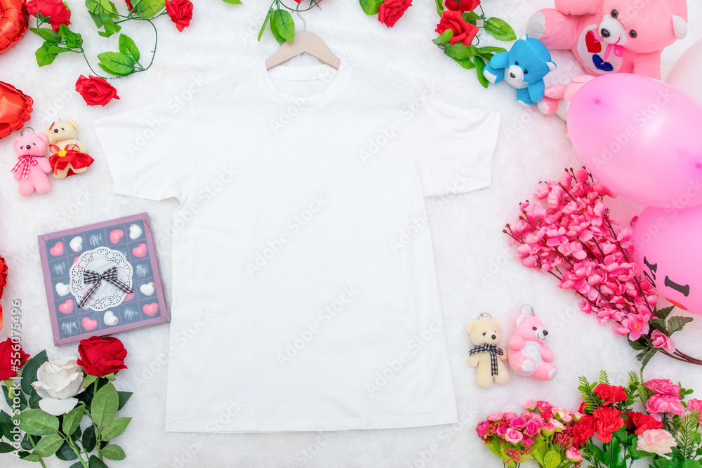 White blank shirt on the top of a fluffy white carpet surrounded by valentine themed decorations White blank shirt on the top of a fluffy white carpet surrounded by valentine themed decorations