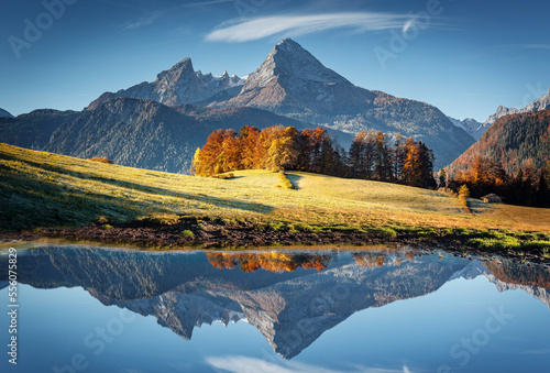 Impressive mountain scenery in the Bavarian Alps. Colorful autumn landscape in the mountains. Watzmann rocky mount reflections in calm alpine lake under sunlight. creative image. Berchtesgaden land