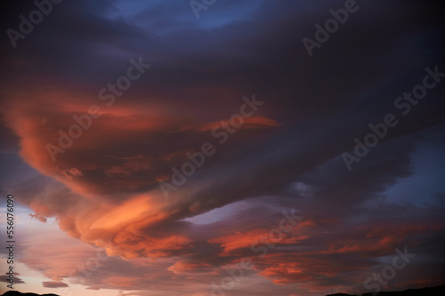 Sunrise with a sky loaded with beautiful clouds with blue and orange colors forming a swirl