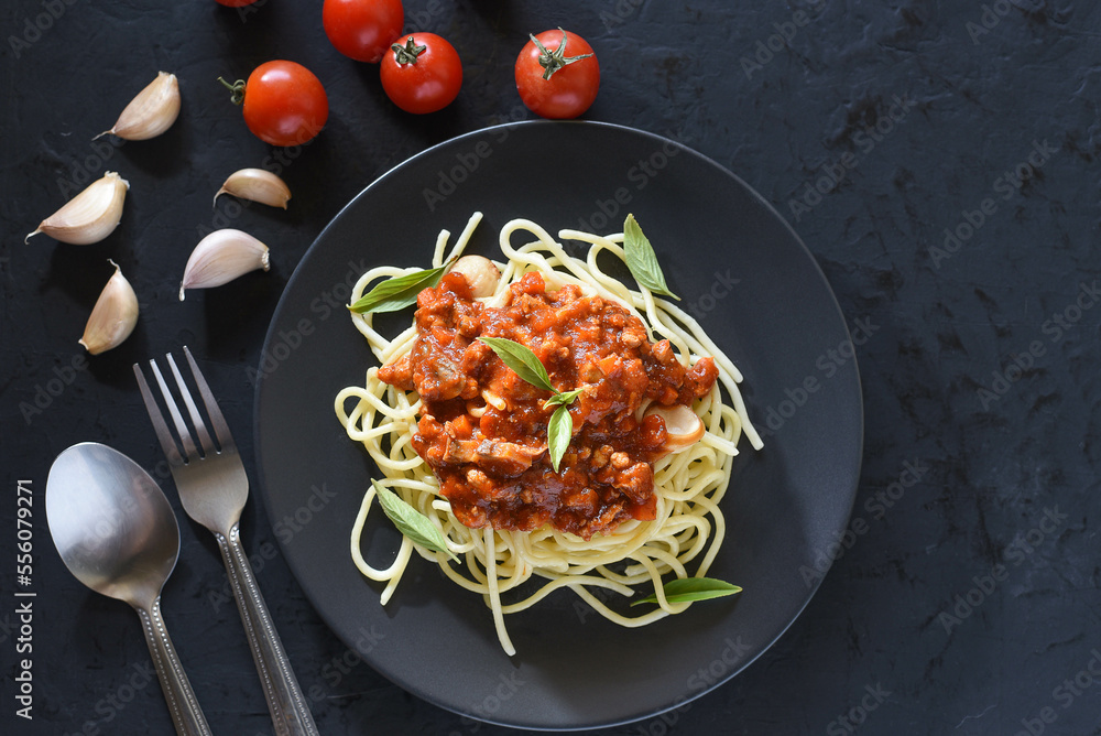 Spaghetti plate on black stone background and space for text.
