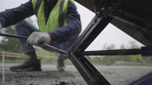 close-up of a man lifting a car with a jack. Breakdown of the car in the threshold on the car. High quality 4k footage