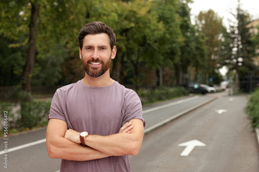 Portrait of handsome bearded man on street, space for text