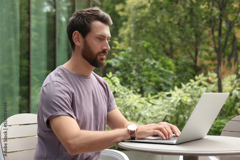 Handsome man with laptop in outdoor cafe Handsome man with laptop in outdoor cafe
