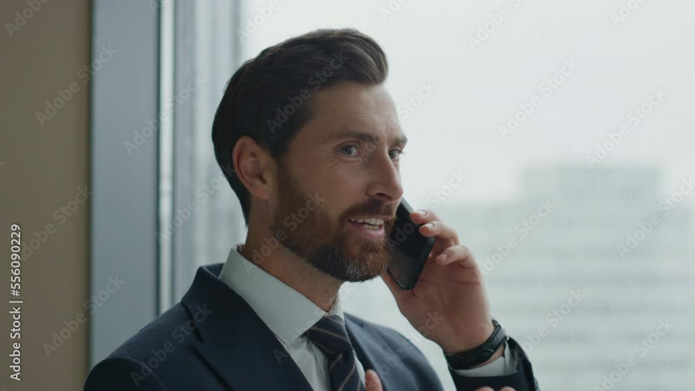 Manager have telephone conversation with partners at panoramic window close up Manager have telephone conversation with partners at panoramic window close up