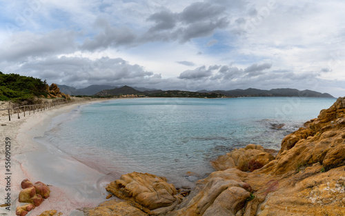 landscape view Porto Giunco Beach near Villasimius in Sardinia with red granite boulders in the foreground