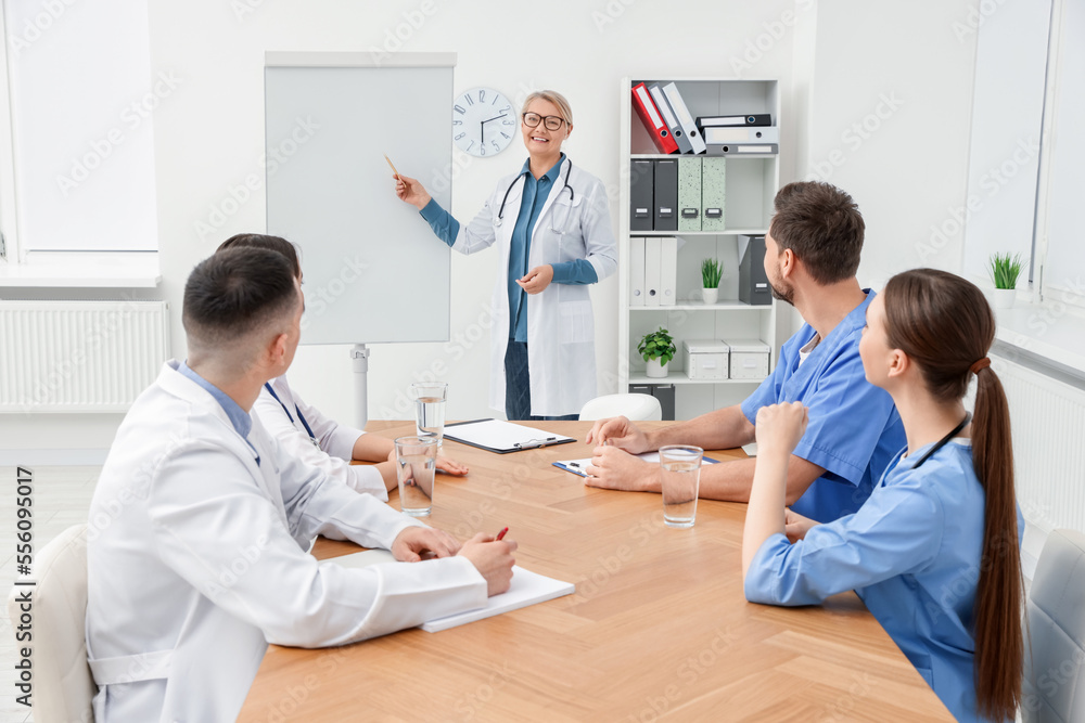Fototapeta premium Doctor giving lecture near flipchart in conference room