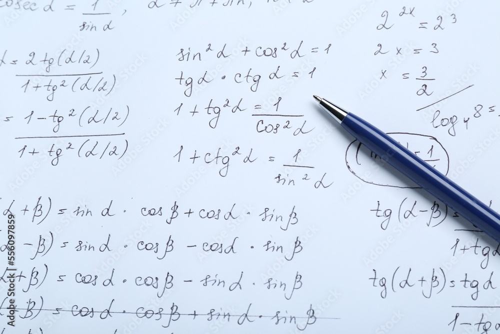 Sheet of paper with different mathematical formulas and pen, top view Sheet of paper with different mathematical formulas and pen, top view