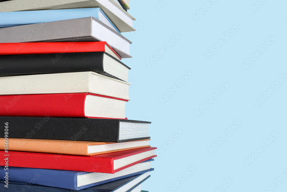 Stack of different books on light blue background, space for text Stack of different books on light blue background, space for text