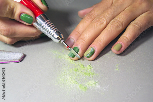 The process of removing gel polish with a grinder. Removal of varnish from women s nails. home machine manicure. Horizontal image.