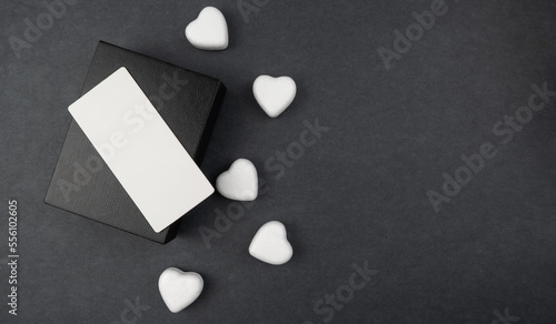 Gift black box with white hearts on a gray background. Holiday concept. Valentine's Day. Present.