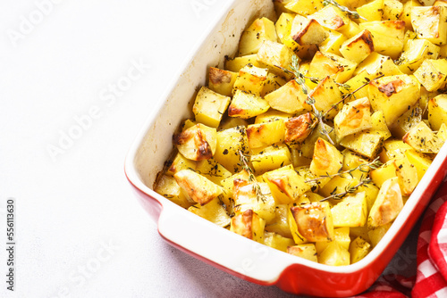 Baked potato with thyme on dark rustic table.