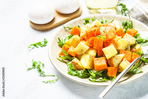 Warm salad with pumpkin, potato and arugula.