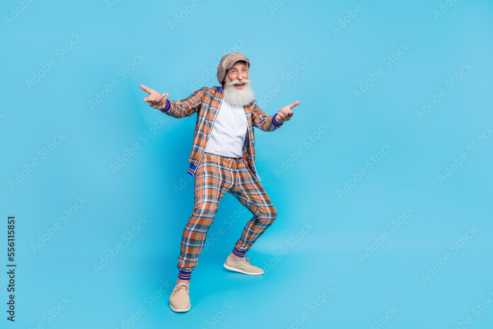 Full length photo of carefree stylish senior guy wear checkered retro suit invite you join celebration isolated on blue color background