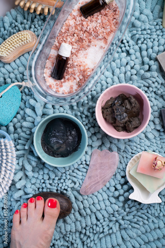 natural  healing  spa set with salt, healing mud and soap on blue bath mat. flay lay