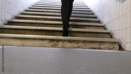 pieds avec talons d'une jeune femme montant des escaliers de métro photo