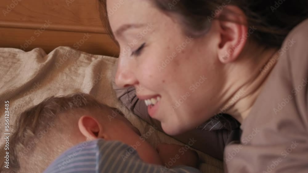 mom next to a sleeping baby. sleeping baby. mom whispers in the ear of a sleeping child. mom kisses sleeping baby mom next to a sleeping baby. sleeping baby. mom whispers in the ear of a sleeping child. mom kisses sleeping baby