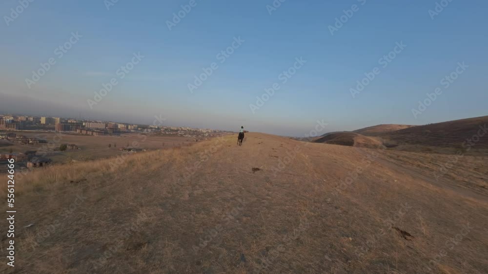 FPV sports drone backward shot active woman riding horse on countryside route path mountain autumn sunset sunrise scenery aerial view. Equine walking suburb nature landscape freedom exploration travel FPV sports drone backward shot active woman riding horse on countryside route path mountain autumn sunset sunrise scenery aerial view. Equine walking suburb nature landscape freedom exploration travel