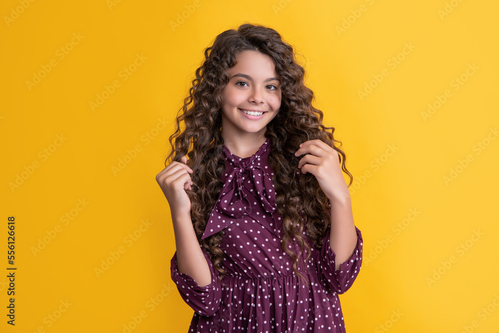 smiling child with long brunette curly hair on yellow background smiling child with long brunette curly hair on yellow background